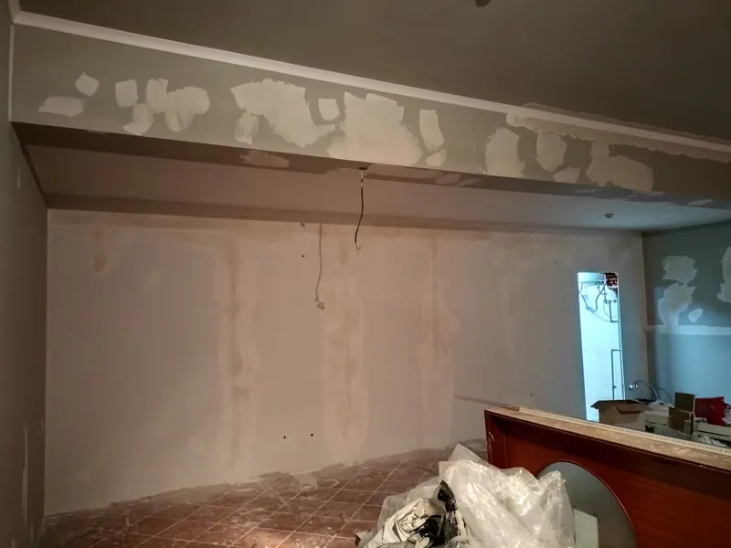 Antes: a mesma parede com reboco danificado e materiais espalhados